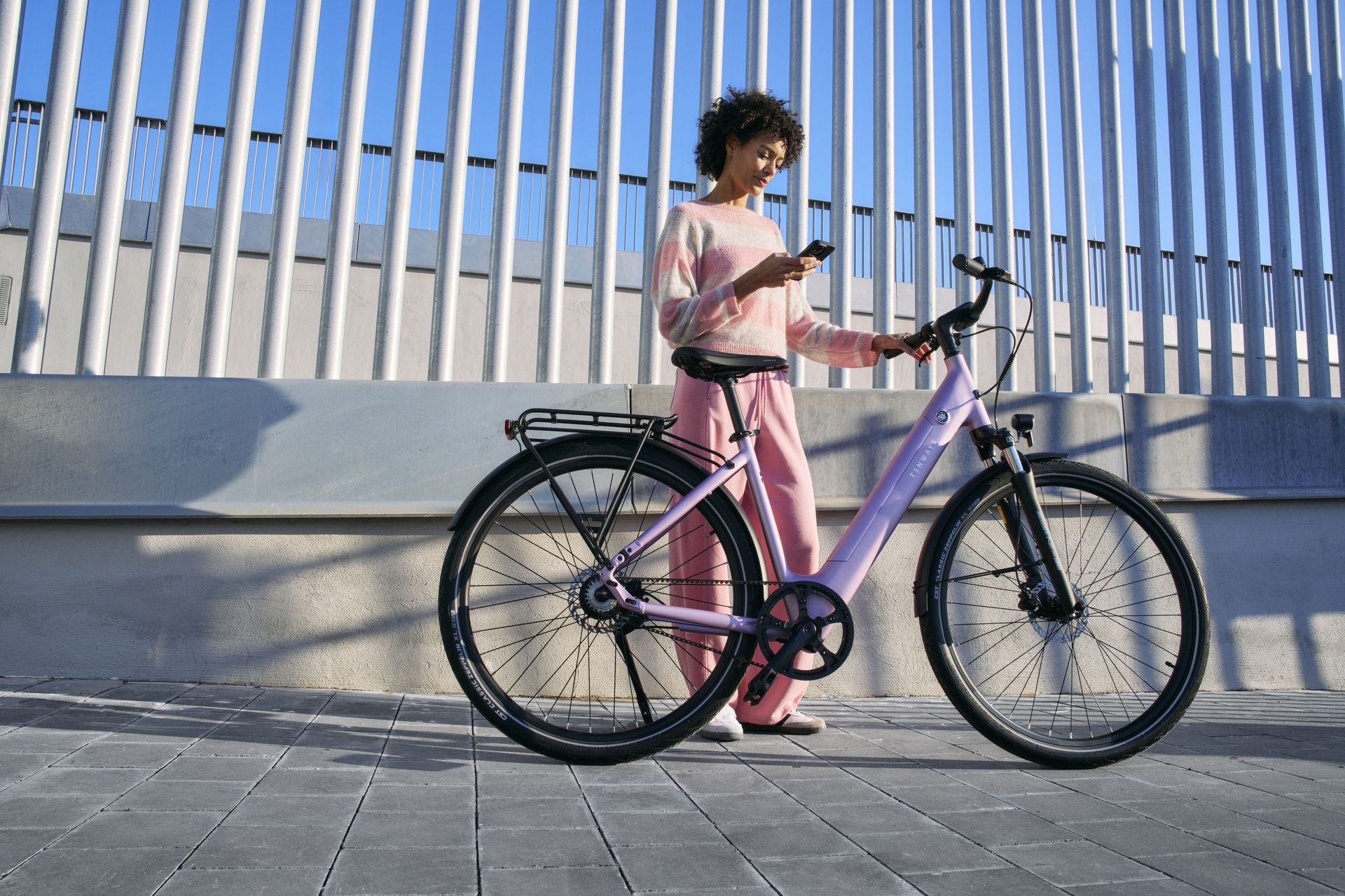 Rijder met een Tenways e-bike voor een modern gebouw